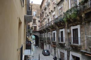 巴勒莫Arco Cutò casa vacanze的街道上一条有建筑和停车场的小巷