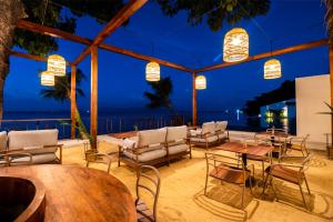 苏梅岛The Flow Samui Beach Resort的一个带桌椅的庭院,晚上则享有海景
