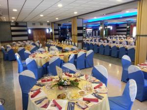 阿索维斯波新镇Hotel La Moraleda - Complejo Las Delicias的宴会厅配有桌子和蓝色椅子