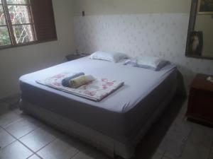 沙帕达-杜斯吉马朗伊斯Casa das Flores的卧室内的一张大床,配有白色床罩