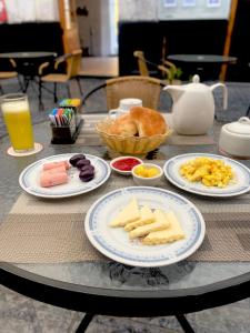 阿雷基帕Hotel La Posada Del Sol的一张桌子,上面放有奶酪、面包和橙汁盘