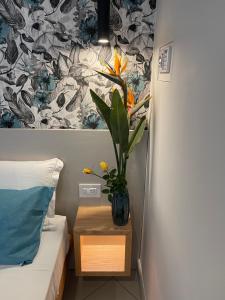 特罗佩阿Sapore Di Sale Accommodation Tropea的一间有床的房间,一个花瓶里装有植物