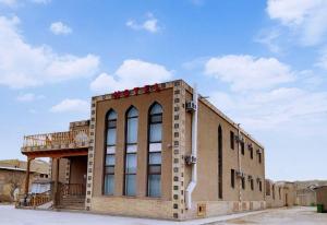 希瓦Hotel Euro Asia Khiva in Ichan Qala的一座砖砌建筑,上面设有阳台