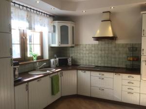 洛格沃Dom za Wydmą的厨房配有白色橱柜、水槽和窗户。