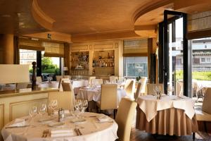 安特卫普希立特酒店的餐厅设有白色的桌椅和窗户。