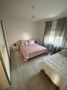 波雷奇Villa Nina Poreč的一间卧室配有一张带粉红色棉被的床