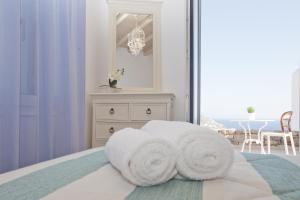 埃利亚海滩Niriides Homes & Villas的白色卧室,配有带毛巾的床