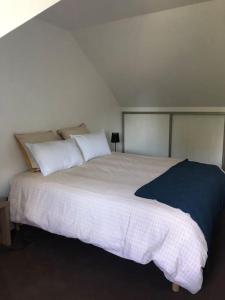 索米尔Cottage 102的卧室配有一张带白色床单和枕头的大床。