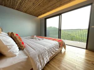Kệ SơnThe Skyview Hòa Bình的一间卧室设有一张大床和一个大窗户