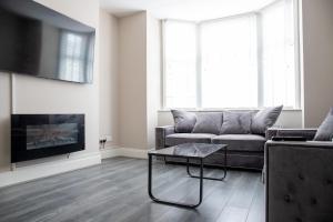 布莱克浦Withnell Stays - Apartment One - Ground Floor的带沙发和咖啡桌的客厅
