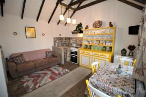 梅奥Geraghtys Farmyard Pods的厨房以及带沙发和桌子的客厅。