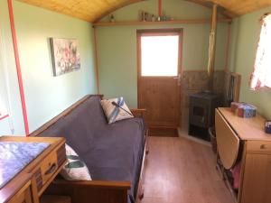 大佩德罗冈Rosa the Cosy Cabin - Gypsy Wagon - Shepherds Hut, RIVER VIEWS Off-grid eco living的带沙发和书桌的客厅