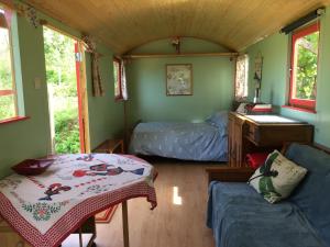大佩德罗冈Rosa the Cosy Cabin - Gypsy Wagon - Shepherds Hut, RIVER VIEWS Off-grid eco living的小房间,配有一张床和一张桌子