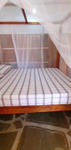 瓦塔穆PWANI HOUSE cottage的配有蚊帐的客房内的一张床位