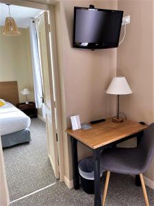 梅尔维尔弗朗瑟维尔普拉格沃邦酒店的酒店客房设有一张桌子和一台墙上的电视。