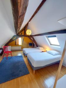 阿姆博斯Le Huis Clos的阁楼卧室配有两张床和蓝色地毯。