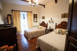 奥利文萨LA CASONA OLIVENTINA的一间卧室设有两张床、一个梳妆台和窗户。