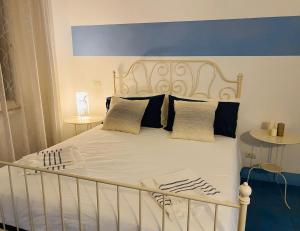 丽都迪奥斯蒂亚Sun&SeaGuestHouse Lido di Roma的一张带蓝色床头板和枕头的白色床