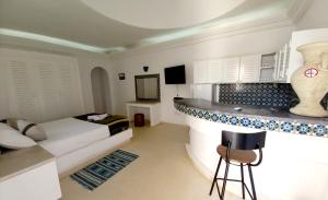 Al ḨaddādahDar ABDELKRIM的一间设有床铺的房间和一间酒吧