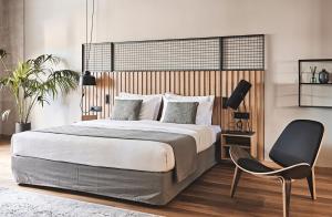雅典Cama Luxury Suites的一间卧室配有一张大床和一把椅子