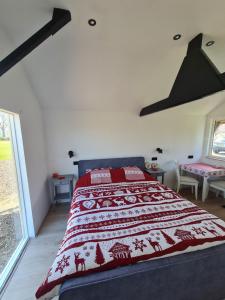 Venhorst't Hûske的一间卧室配有一张带红白毯子的床