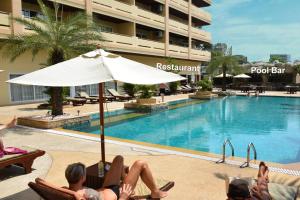 北芭堤雅旺马特海滩美景塔莱6号度假酒店的一群人躺在游泳池旁的椅子上