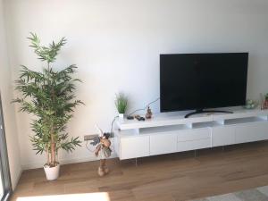 阿尔加德萨Links II 505 Duplex 2bedroom Apartment GOLF Alcaidesa SPAIN的客厅配有白色橱柜上的平面电视