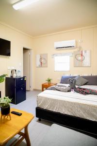 莫尔兹比港Green Hills Accommodation Village的一间卧室配有一张大床和一张桌子