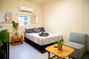 莫尔兹比港Green Hills Accommodation Village的一间卧室配有一张床、一把椅子和一张桌子