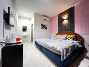 珍南海滩Little Chenang Cottage Motel Langkawi的一间卧室配有一张床和一台电视。