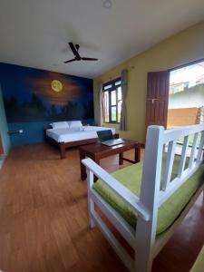 KawasotiGreen Chwadi Nature Retreat的一间卧室配有一张床、一张桌子和一张沙发