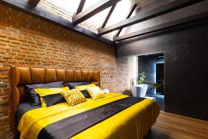 Luka nad JihlavouRASL House的一间卧室配有一张黄色的床和砖墙