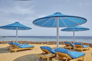 沙姆沙伊赫Pickalbatros Royal Grand Sharm - Adults Friendly 16 Years Plus的海滩上的一组椅子和遮阳伞