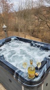 保拉德Mountain cottage的热水浴池,内含2杯葡萄酒