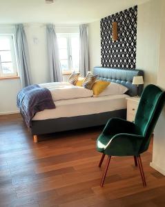 迪森阿姆阿梅尔塞Schatzbergalm Pension的一间卧室配有一张大床和一张绿色椅子