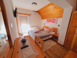 普利特维采湖Plitvice Green Valley的一间卧室配有带粉红色枕头的床。