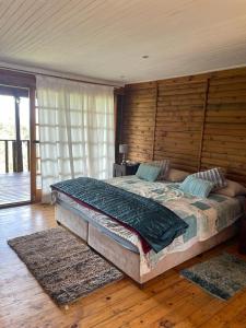 KwaMazambaneKosy place的一间卧室设有一张带木墙的大床
