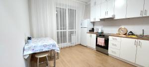 PrigorodnyyБудапешт 197的厨房配有白色橱柜和桌子