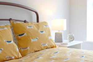 亨斯坦顿伊利茵布鲁克旅馆的一间卧室配有一张带黄色床单和枕头的床。