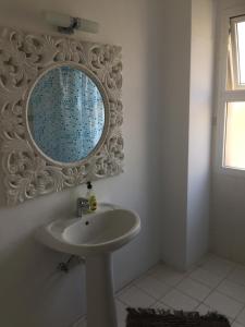 帕福斯Vangelios Apartments的浴室设有水槽和墙上的镜子