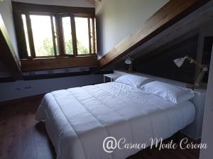 UdiasCasa con encanto en La Hayuela, situada a 5 min de Comillas的卧室设有一张白色大床和两个窗户。