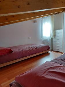 兰佐丁泰尔维Incantevole appartamento con piscina e vista monti的一间卧室设有两张床和窗户。