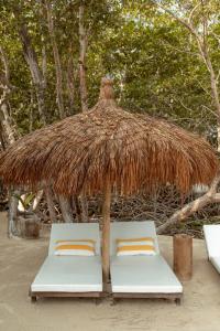 卡塔赫纳Fragata Island House的海滩上稻草伞下的两张床