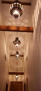阿利坎特LA CASA MORISCA的走廊上设有吊灯,天花板上挂着三个吊灯