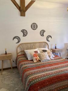 Antully莫尔万塞祖尔旅馆的一间卧室配有一张床铺,墙上挂有枕头和时钟