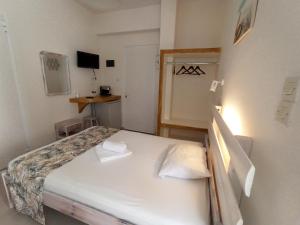 梅加斯·亚洛斯-奈特斯宁静湾旅馆的一间小卧室,配有白色的床和两个枕头