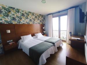 奥亚阿雷纳酒店的一间卧室设有一张大床和一个大窗户