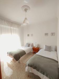 埃希哈Écija Home的一间卧室设有两张床和窗户。