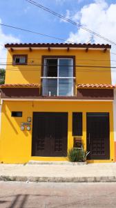 科米坦德多明格斯LA CASA AMARILLA, centrica, barrio local.的黄色房子,有两个黑色车库门