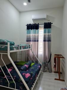 龙运Munirah Homestay的一间卧室设有两张双层床和一扇窗户。